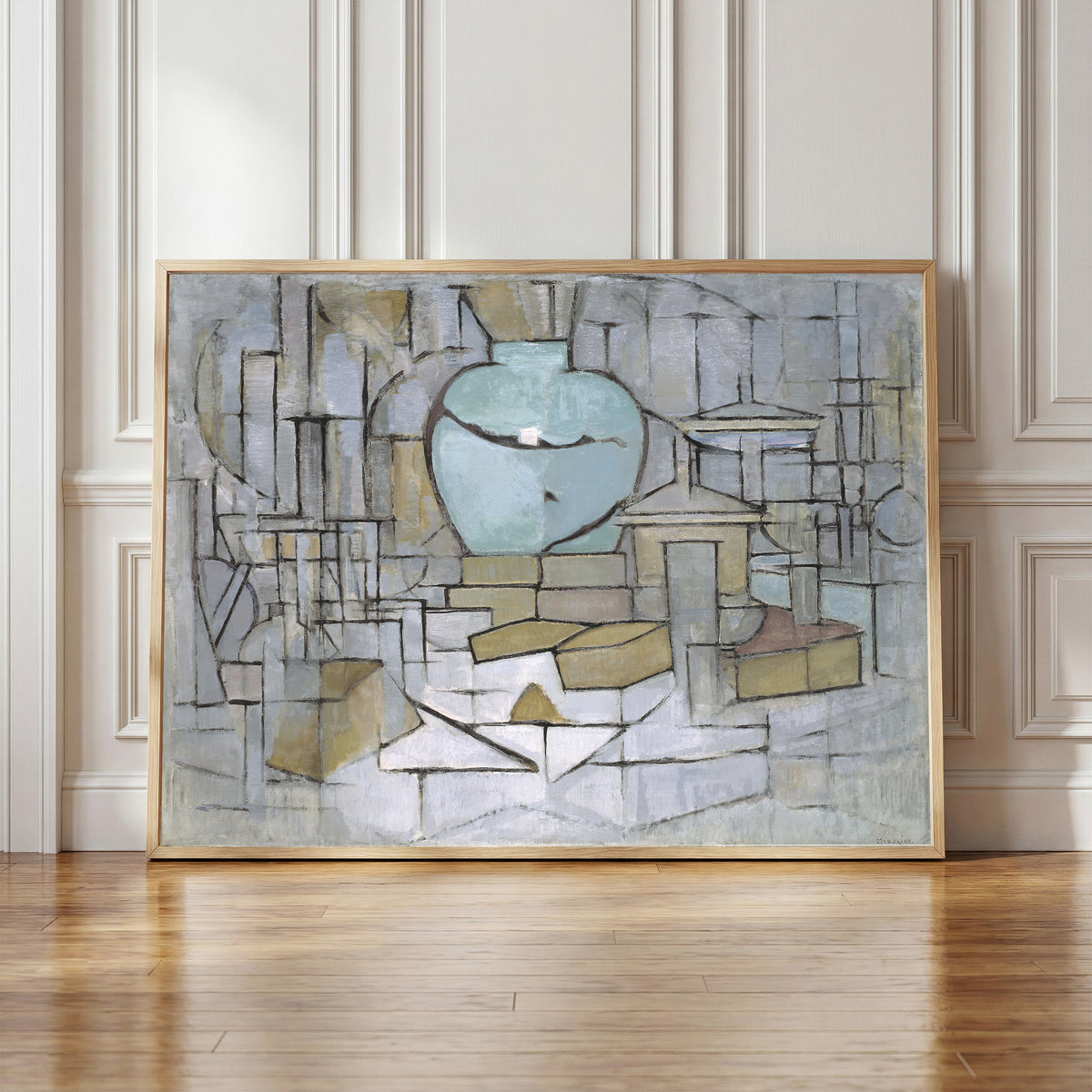 Framed art print of Still Life with Gingerpot II by Piet Mondrian, in a light wood frame leaning against a panelled white wall