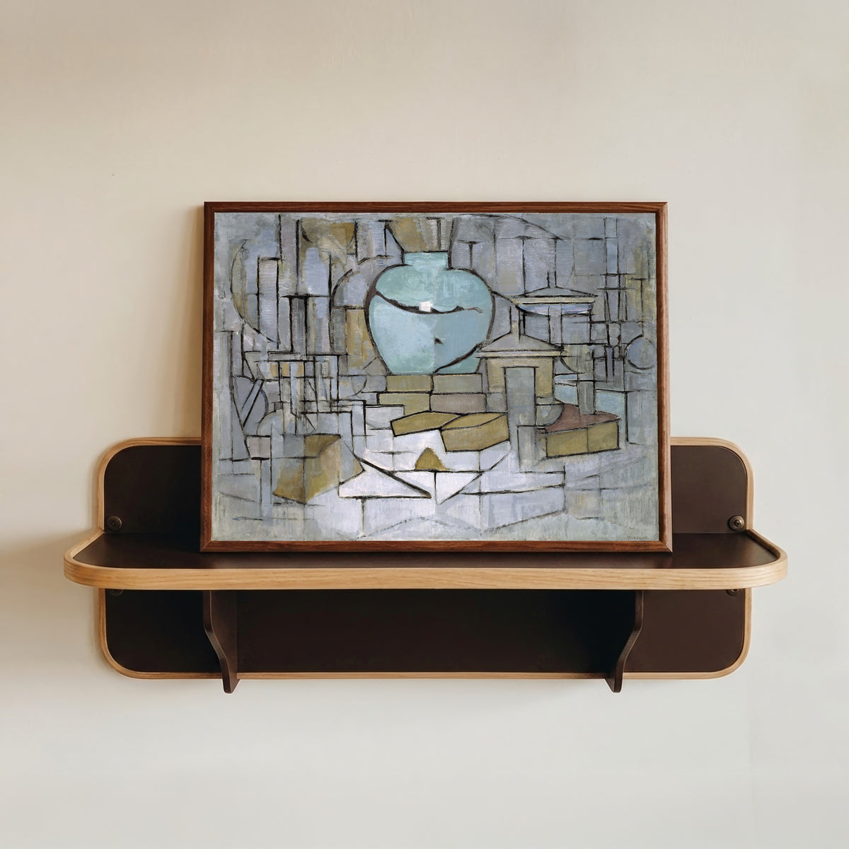 Framed art print of Still Life with Gingerpot II by Piet Mondrian, in a dark wood frame resting on a wall shelf