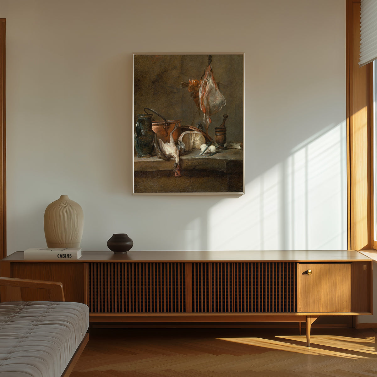 Framed art print of Still Life with Ray and Basket of Onions by Jean-Siméon Chardin, in a thin light frame on a sunlit wall above a wooden sideboard