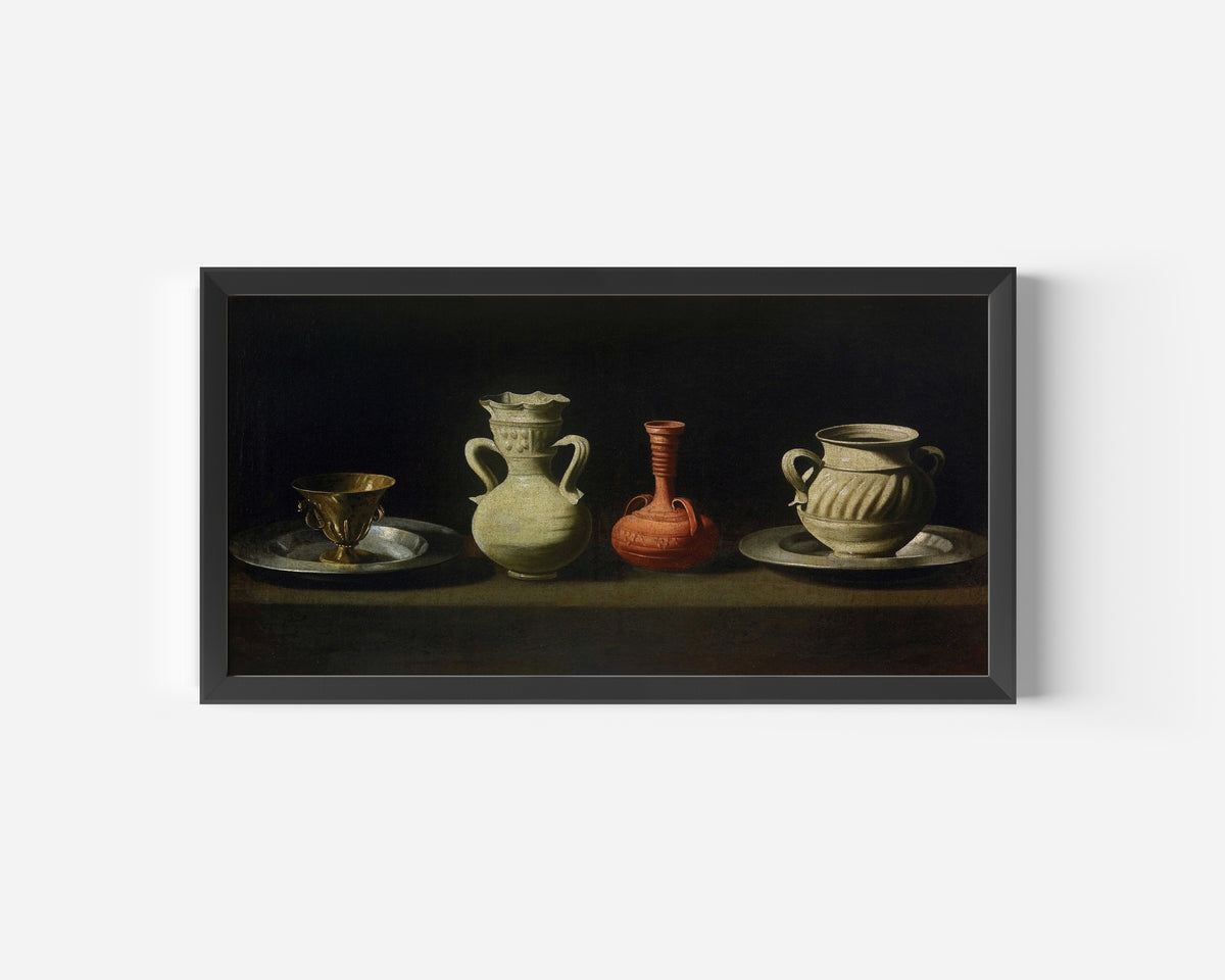 Framed art print of Still Life with Vessels by Francisco de Zurbarán, in a wide black frame on a plain white wall
