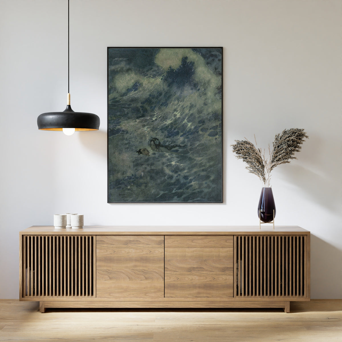Framed art print of Stories from Hans Andersen: The Little Mermaid to the Rescue by Edmund Dulac, above a slatted wood sideboard