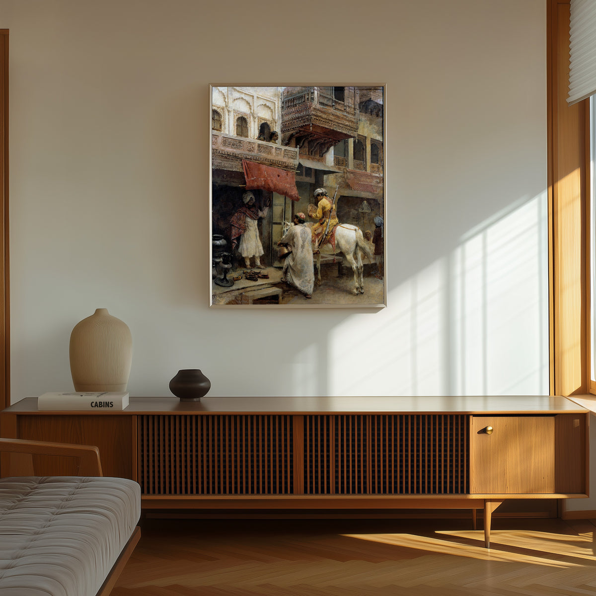 Framed art print of Street Scene in India by Edwin Lord Weeks, in a thin light frame on a sunlit wall above a wooden sideboard