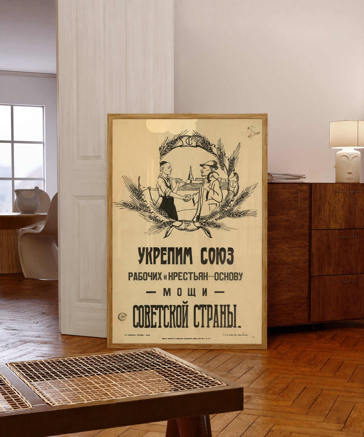 Framed art print of Strengthen the union of workers and peasants, the foundation of the…, in a light wood frame leaning in a warm room with a parquet floor