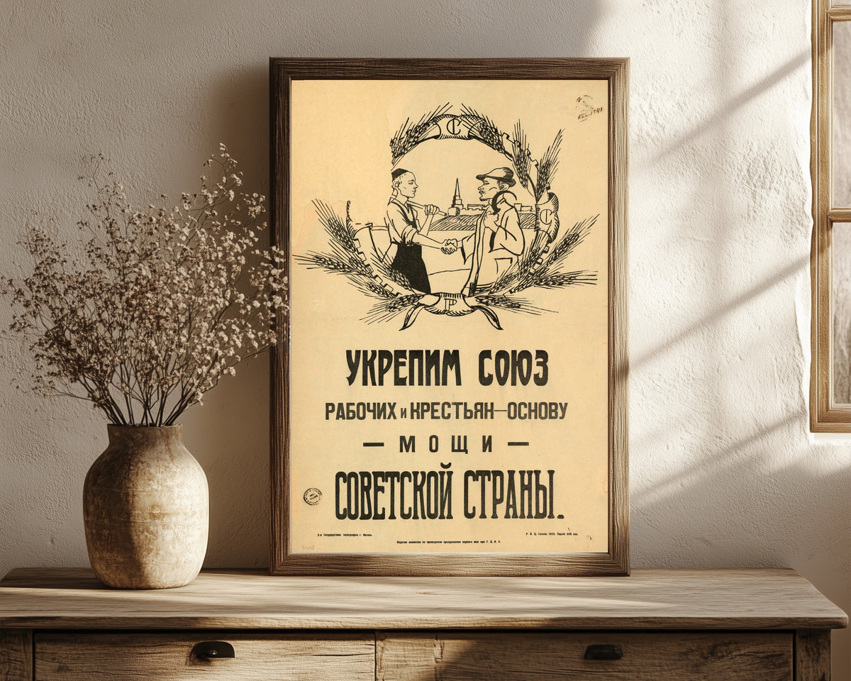 Framed art print of Strengthen the union of workers and peasants, the foundation of the…, in a dark wood frame leaning on a rustic console beside dried flowers