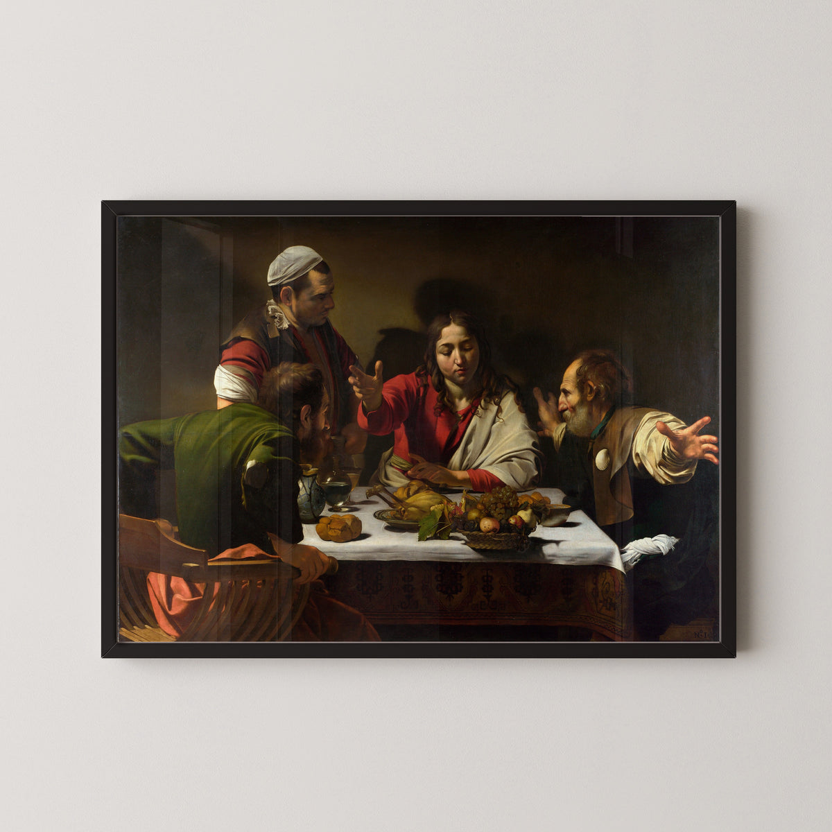 Framed art print of Supper at Emmaus by Caravaggio, in a black frame on a pale wall