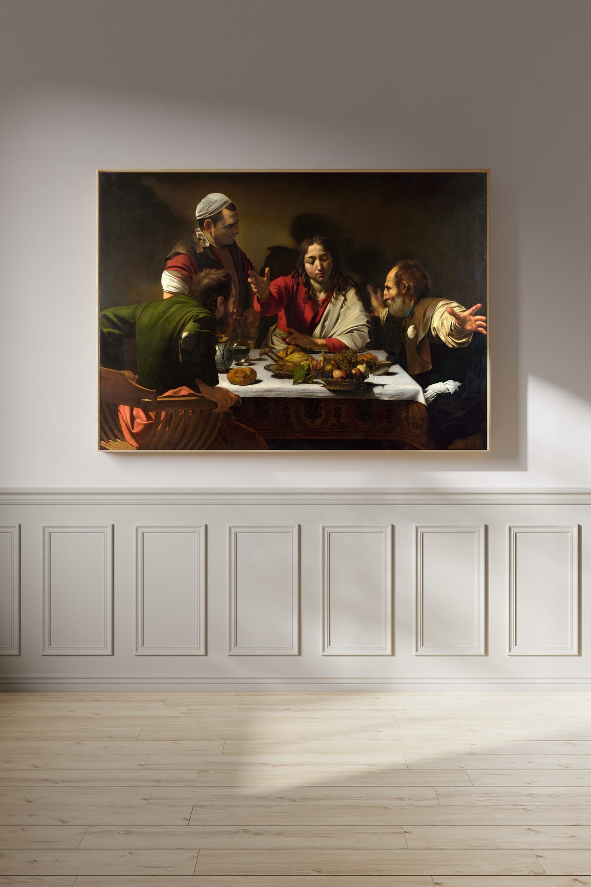 Framed art print of Supper at Emmaus by Caravaggio, on a panelled wall in afternoon light