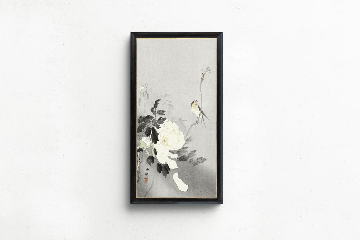 Framed art print of Swallow with Peony by Ohara Koson, in a slim black frame on a plain white wall