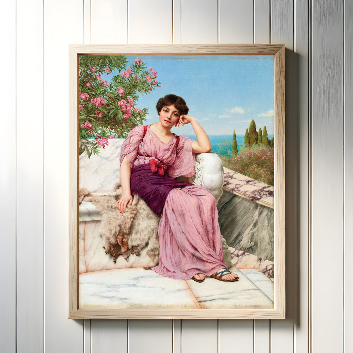 Framed art print of Sweet Dreams by John William Godward, in a light wood frame on a white panelled wall