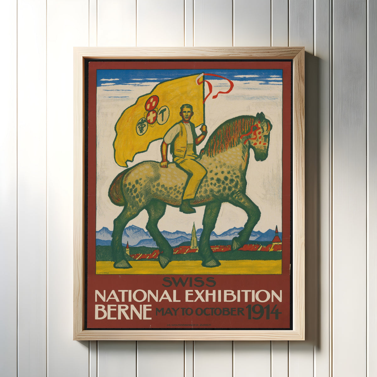 Framed art print of Swiss National Exhibition, Berne 1914 by Emil Cardinaux, in a light wood frame on a white panelled wall