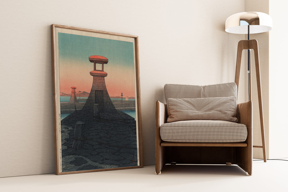 Framed art print of Tadotsu, Sanshu by Kawase Hasui, leaning against a wall beside an armchair and a floor lamp