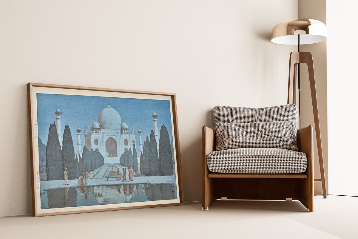 Framed art print of Taj Mahal at Night, No. 6 by Hiroshi Yoshida, leaning against a wall beside an armchair and a floor lamp