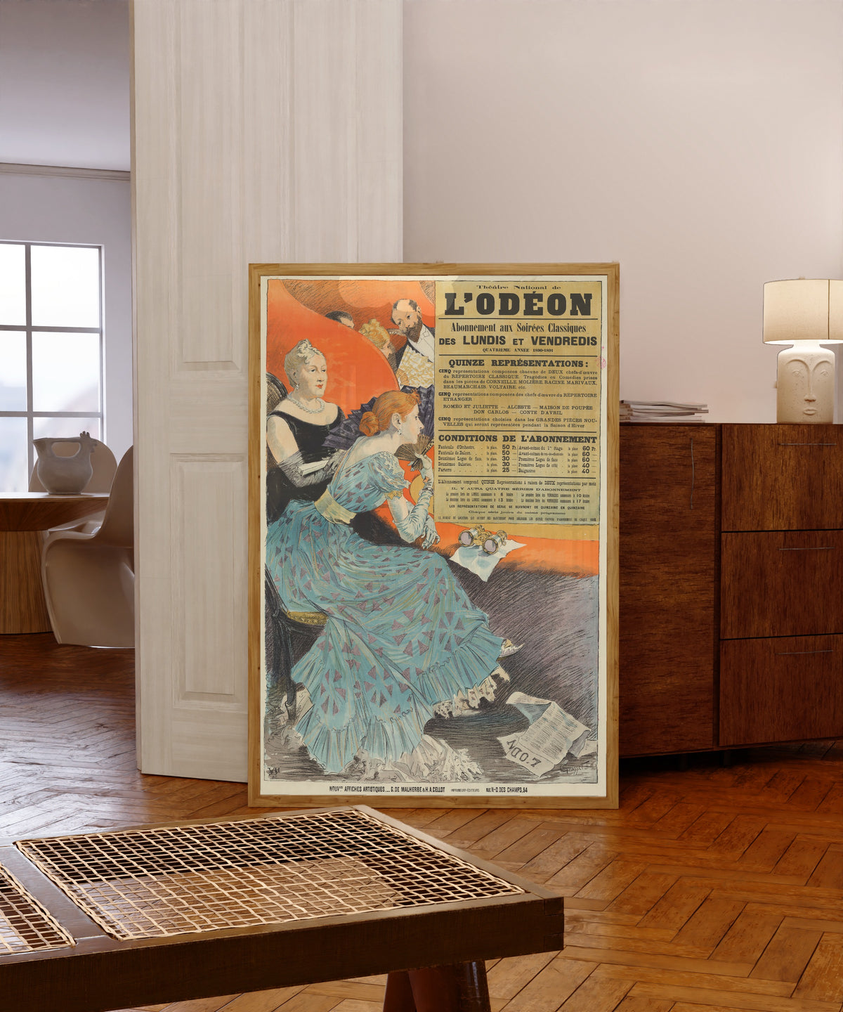 Framed art print of Théatre National de l'Odéon. Abonnement aux soirées… by Eugène Grasset, in a light wood frame leaning in a warm room with a parquet floor