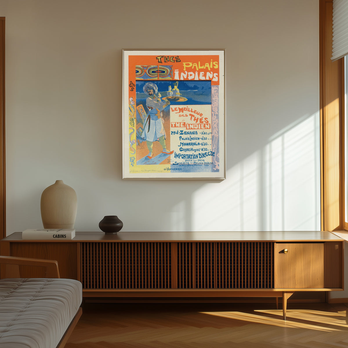 Framed art print of Thés du Palais Indien by Georges de Feure, in a thin light frame on a sunlit wall above a wooden sideboard
