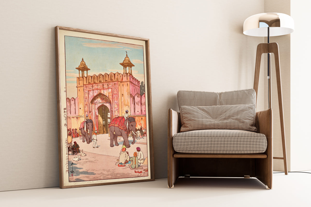 Framed art print of The Ajmer Gate at Jaipur by Hiroshi Yoshida, leaning against a wall beside an armchair and a floor lamp