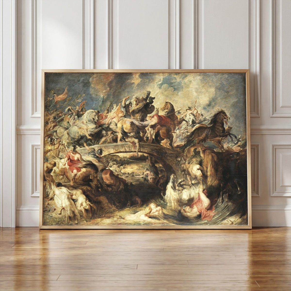 Framed art print of The Battle of the Amazons by Peter Paul Rubens, in a light wood frame leaning against a panelled white wall