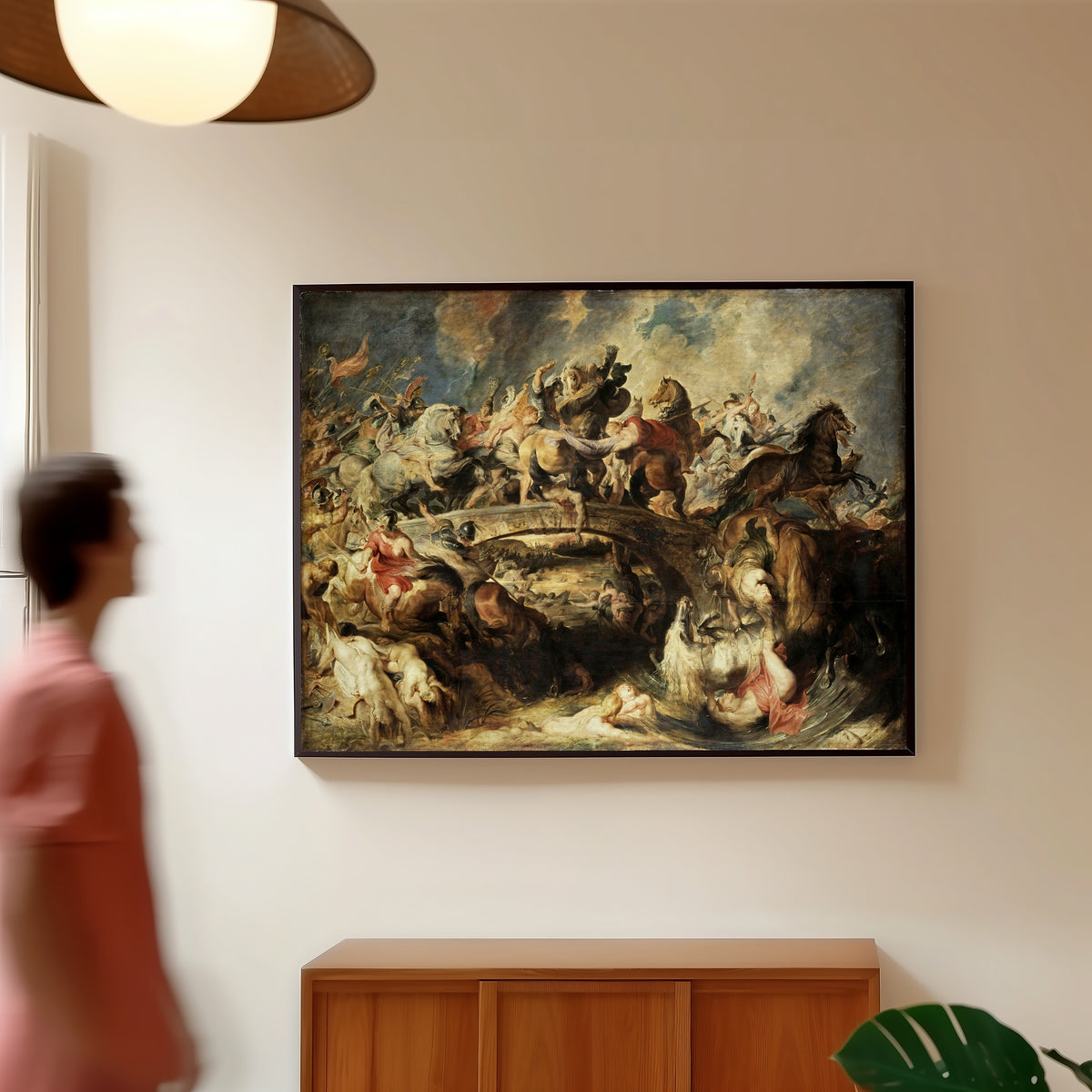 Framed art print of The Battle of the Amazons by Peter Paul Rubens, in a slim black frame on a warm wall in a sunlit room