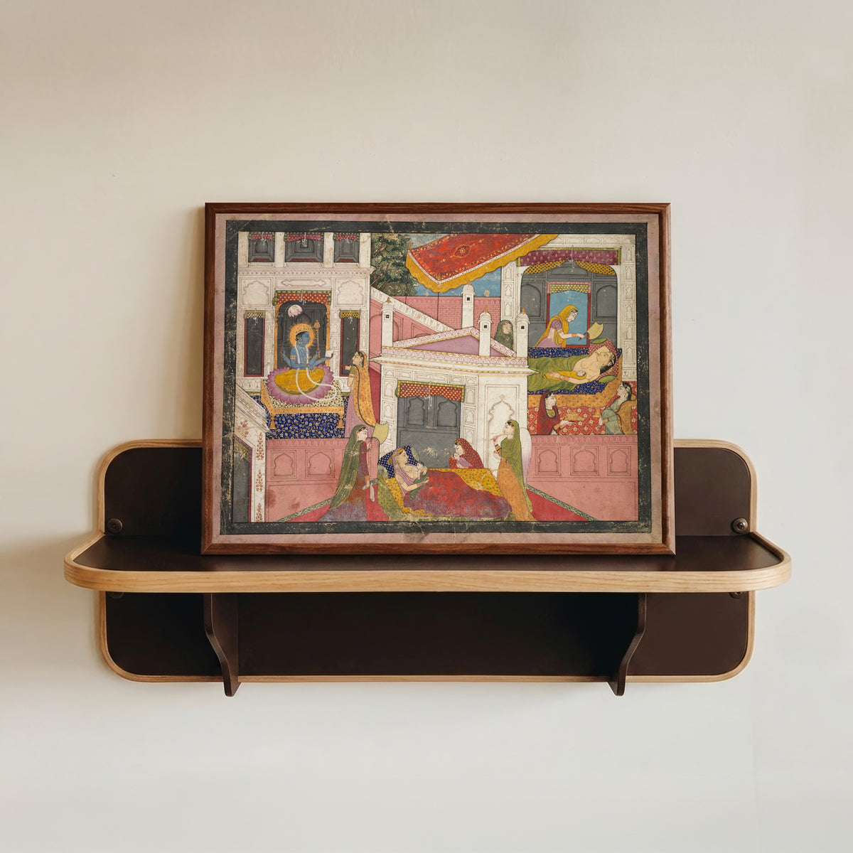 Framed art print of The Birth of Rama and His Brothers, from the Bala Kanda of the Adhyatma… by Kangra school, in a dark wood frame resting on a wall shelf
