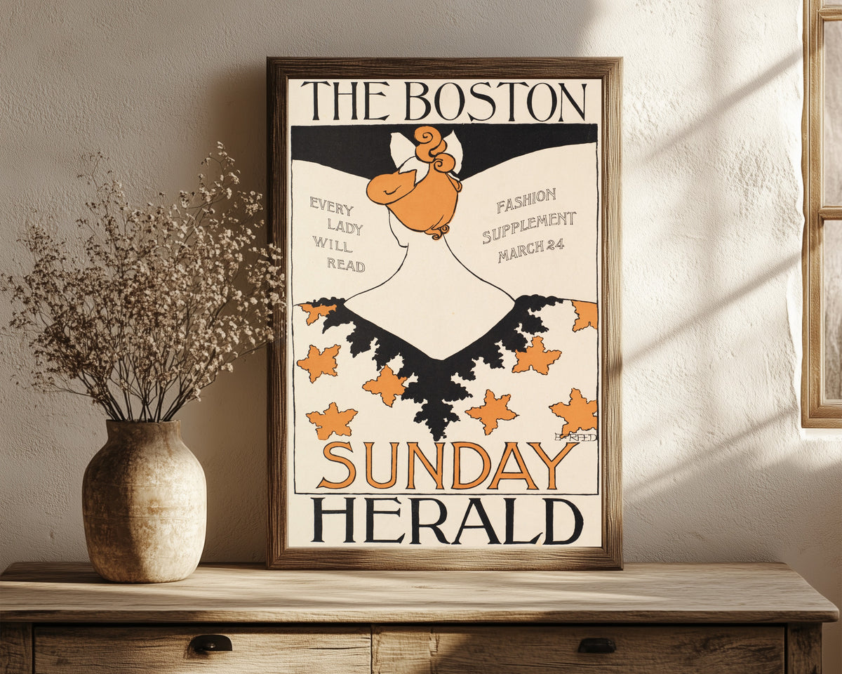 Framed art print of The Boston Sunday Herald, Every Lady Will Read… by Ethel Reed, in a dark wood frame leaning on a rustic console beside dried flowers
