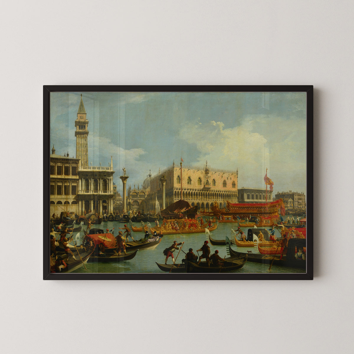 Framed art print of The Bucintore Returning to the Molo on Ascension Day by Canaletto, in a black frame on a pale wall