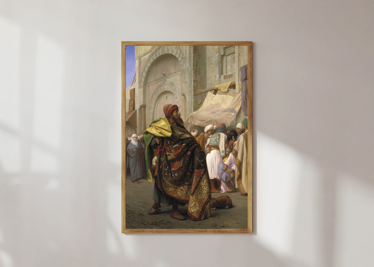 Framed art print of The Carpet Merchant of Cairo by Jean-Léon Gérôme, in a light wood frame on a sunlit white wall