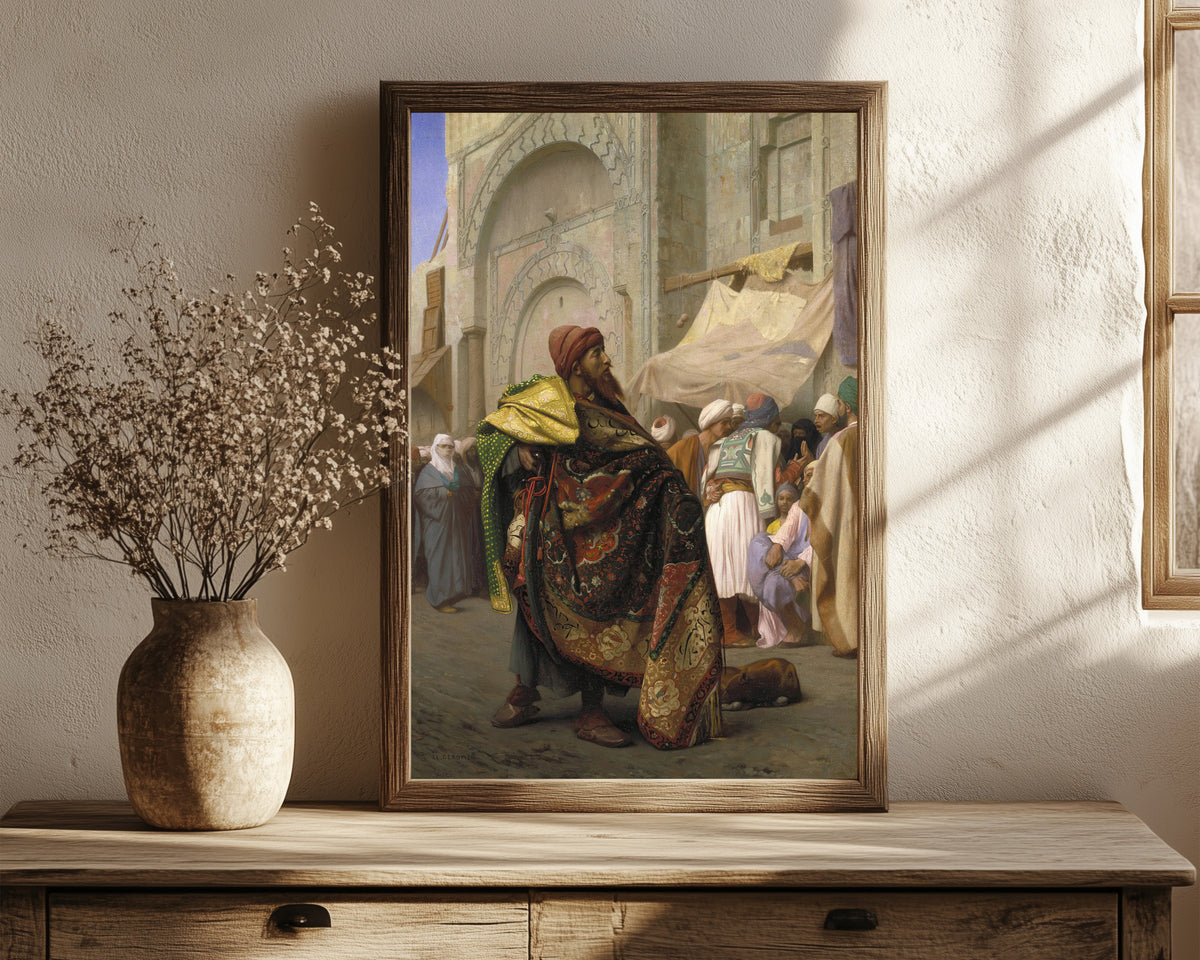 Framed art print of The Carpet Merchant of Cairo by Jean-Léon Gérôme, in a dark wood frame leaning on a rustic console beside dried flowers