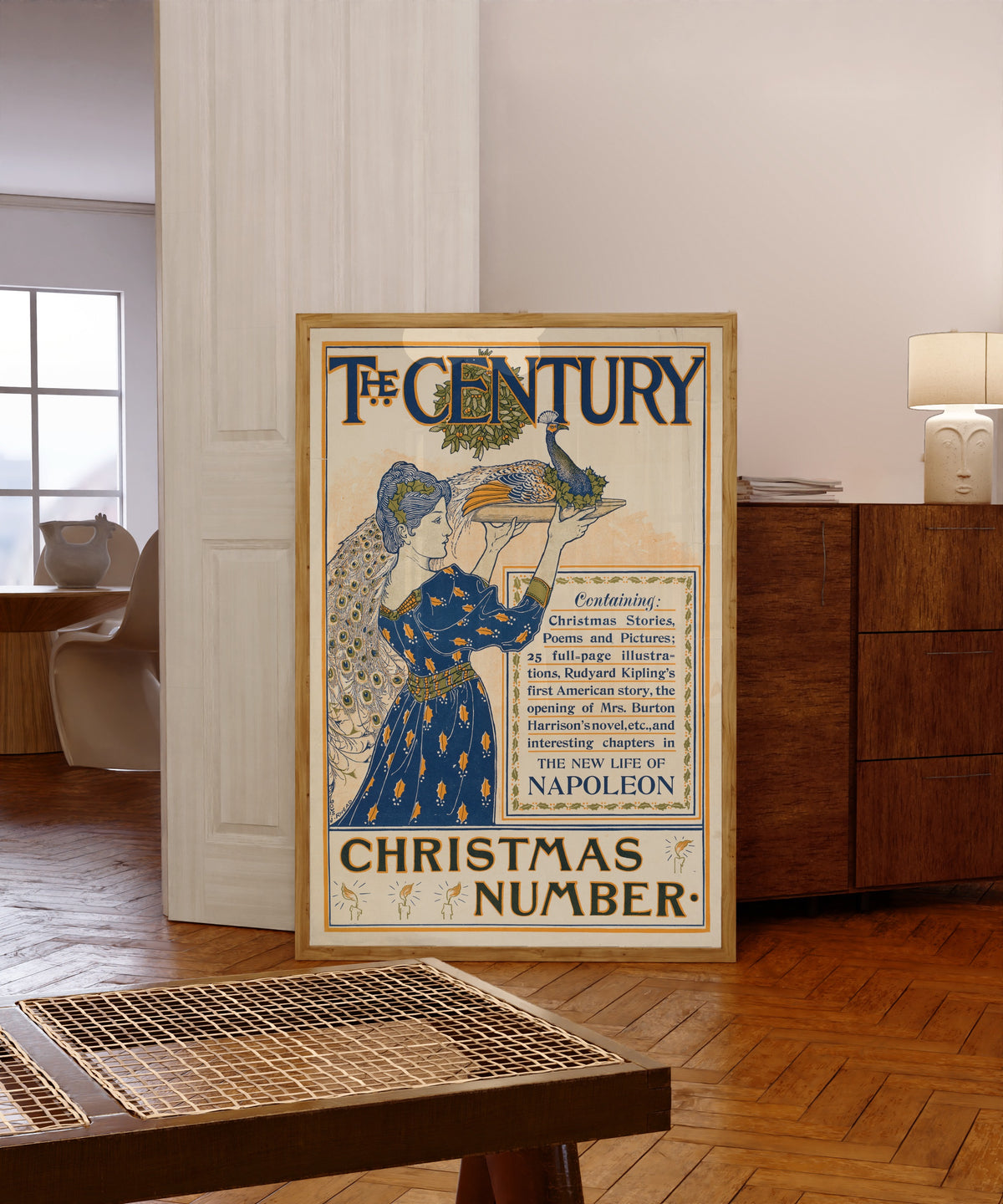 Framed art print of The Century, Christmas Number by Louis Rhead, in a light wood frame leaning in a warm room with a parquet floor