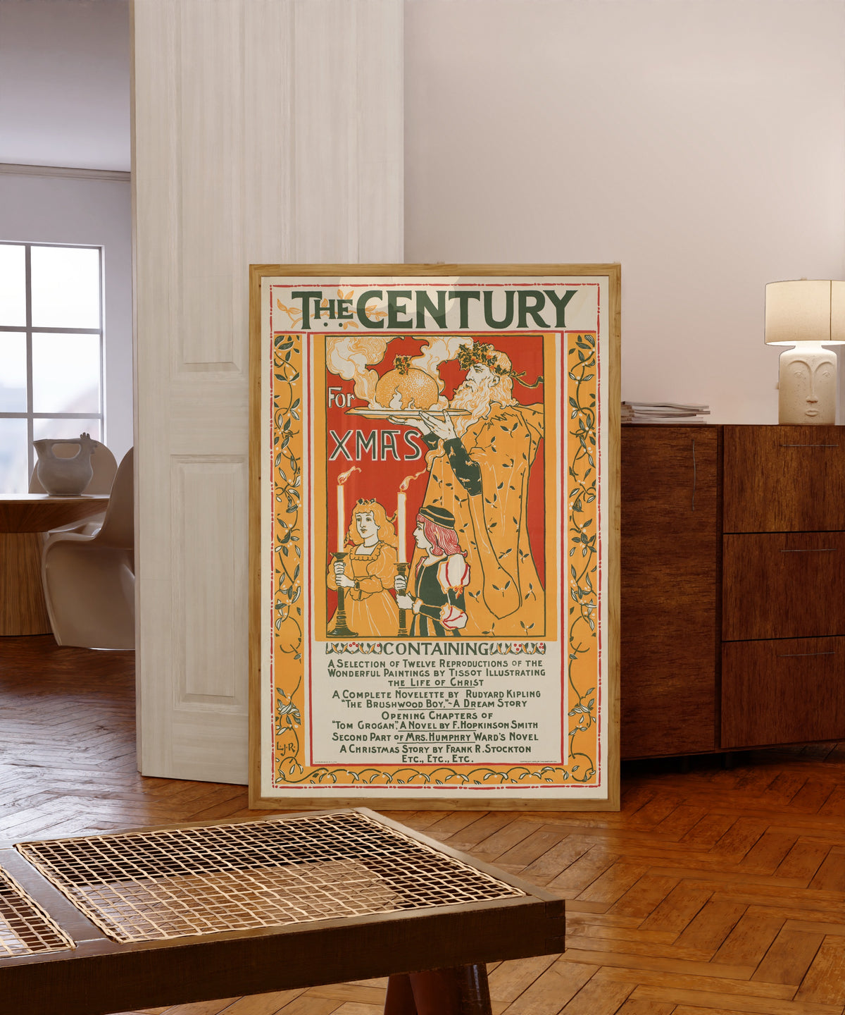 Framed art print of The Century for Xmas by Louis Rhead, in a light wood frame leaning in a warm room with a parquet floor