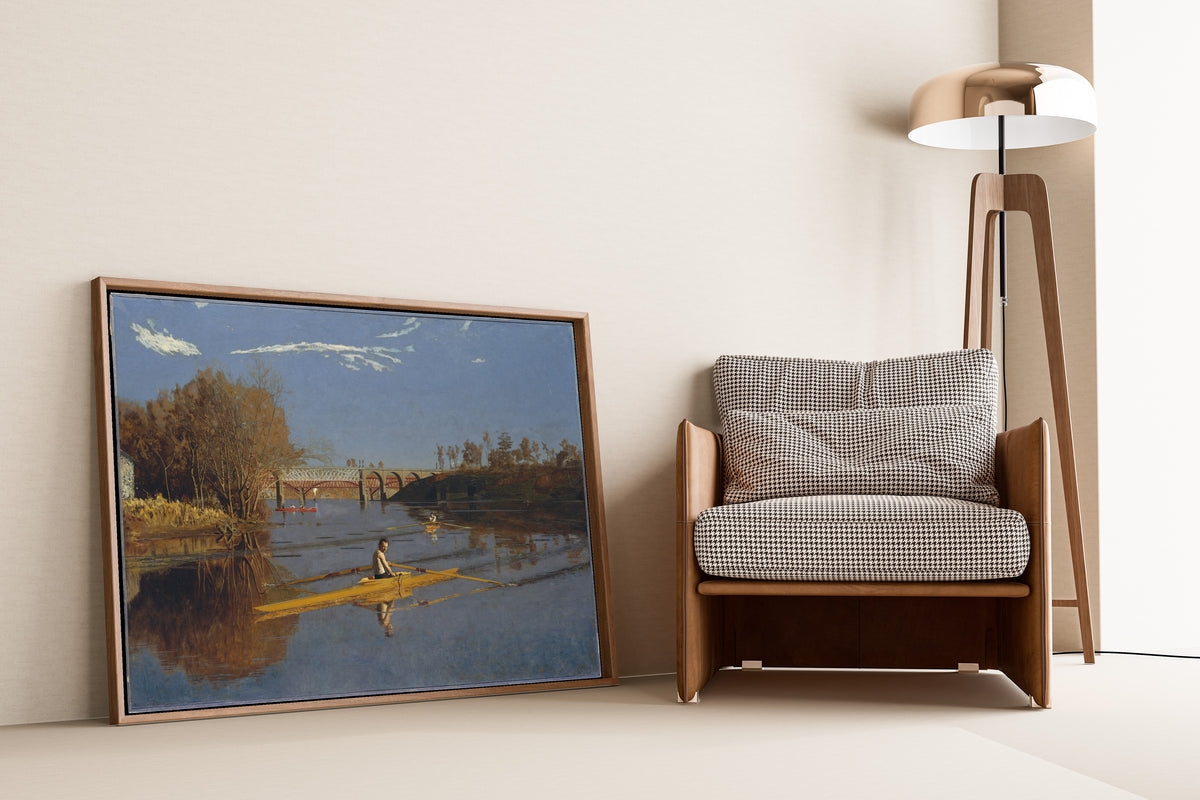 The Champion Single Sculls (Max Schmitt in a Single Scull) by Thomas Eakins — framed and leaning against a wall beside an armchair and a floor lamp