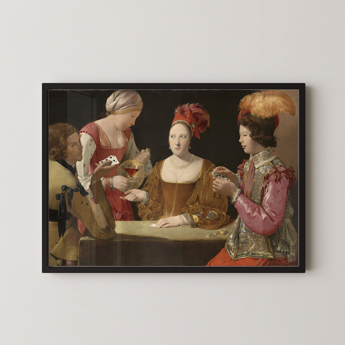 Framed art print of The Cheat with the Ace of Clubs by Georges de La Tour, in a black frame on a pale wall