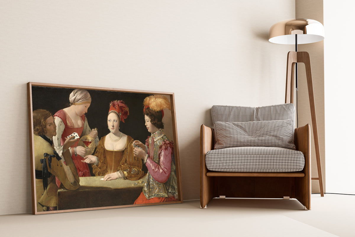 Framed art print of The Cheat with the Ace of Clubs by Georges de La Tour, leaning against a wall beside an armchair and a floor lamp