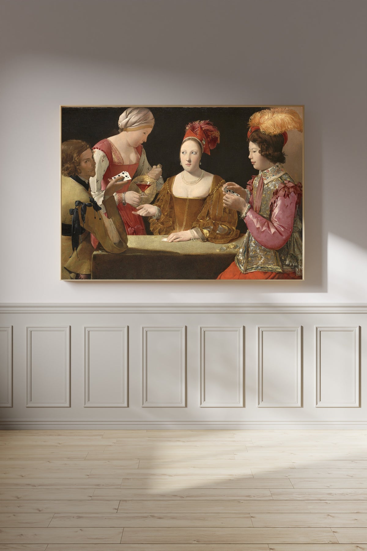 Framed art print of The Cheat with the Ace of Clubs by Georges de La Tour, on a panelled wall in afternoon light