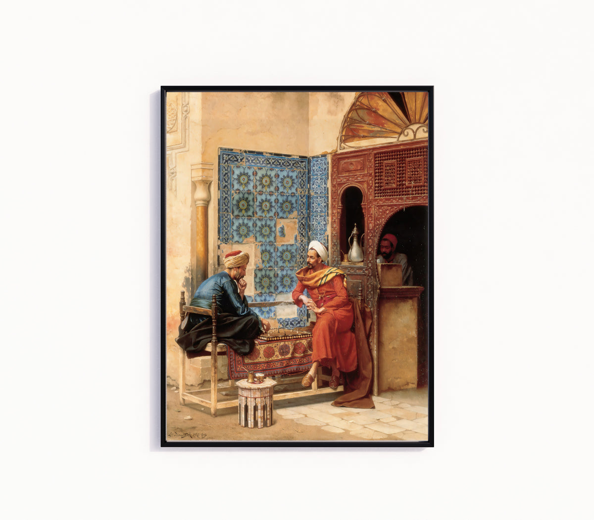 Framed art print of The Chess Game by Ludwig Deutsch, in a slim black frame on a plain white wall