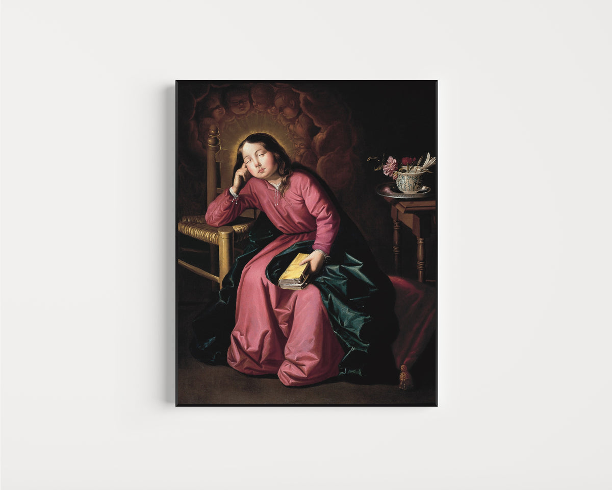 Framed art print of The Child Virgin Asleep by Francisco de Zurbarán, in a slim black frame on a plain white wall