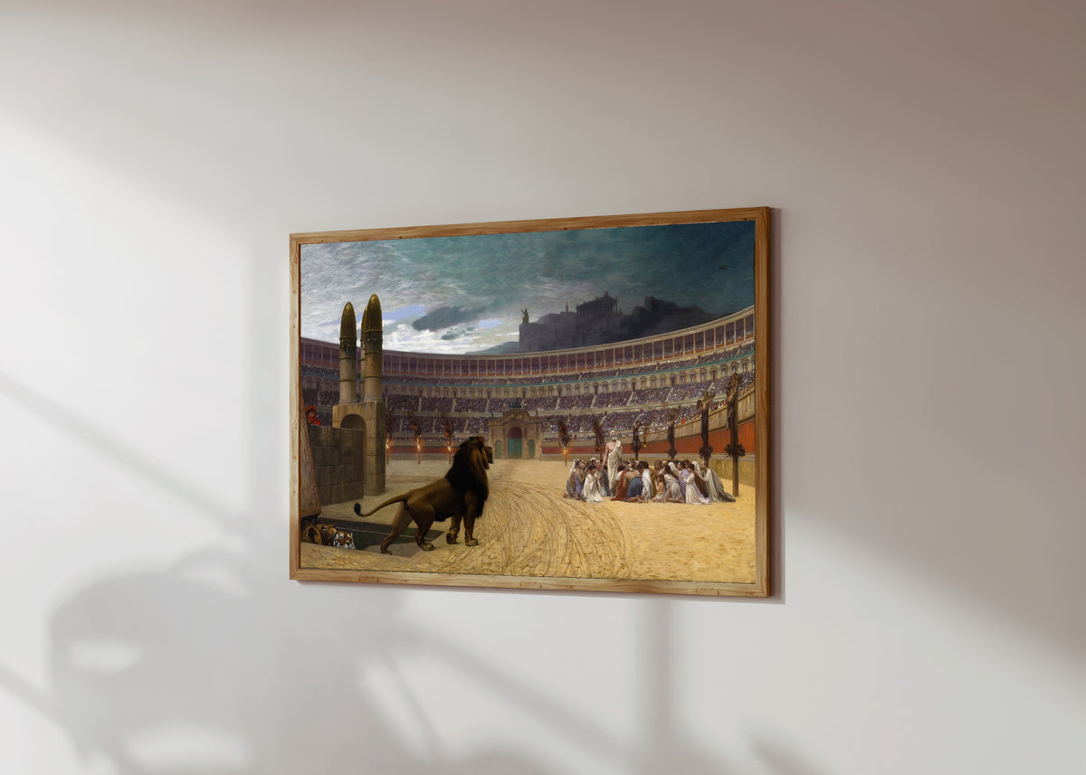 Framed art print of The Christian Martyrs' Last Prayer by Jean-Léon Gérôme, in a light wood frame on a sunlit white wall, seen at a slight angle