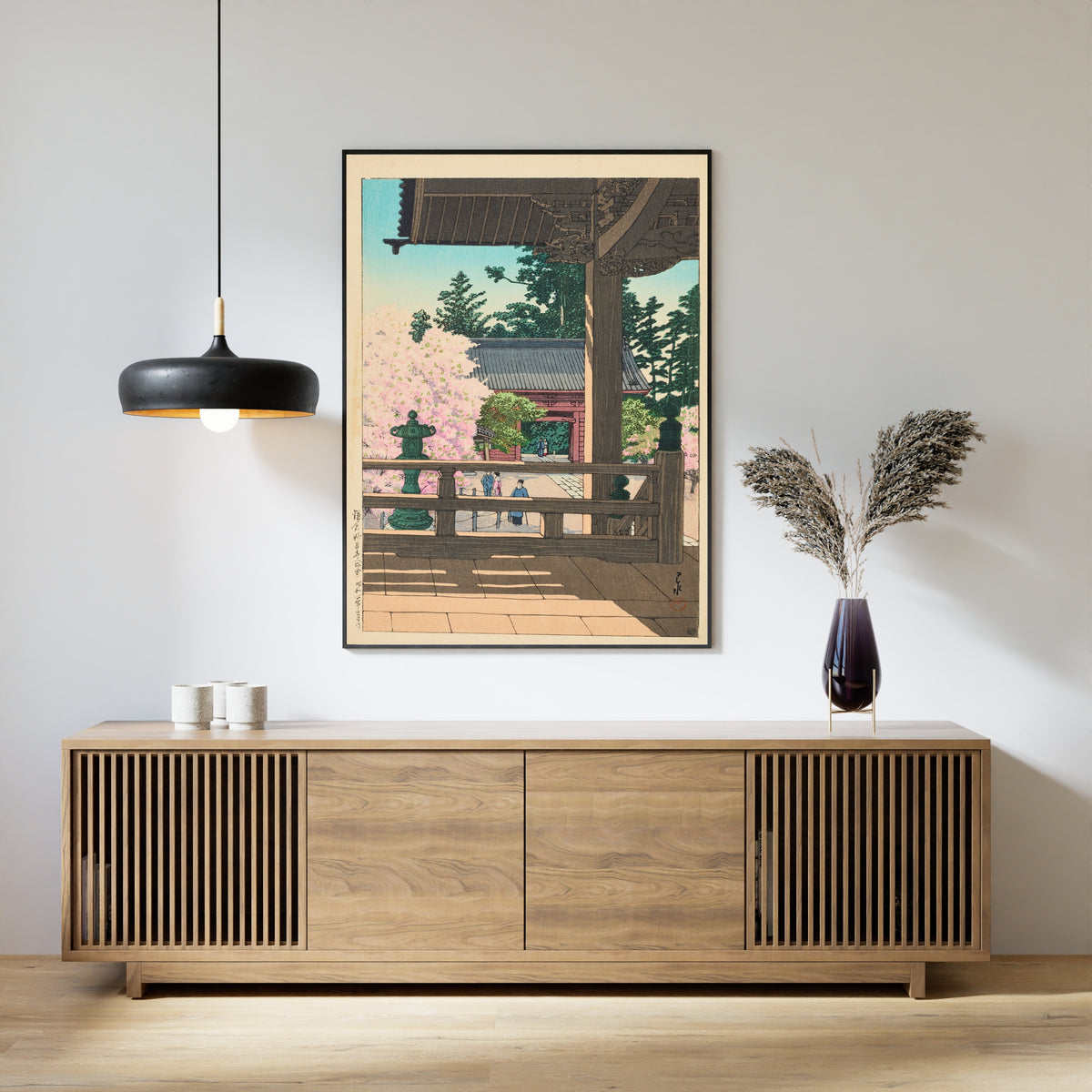 Framed art print of The Crabapple Flowers in Myohonji Temple, Kamakura by Kawase Hasui, above a slatted wood sideboard