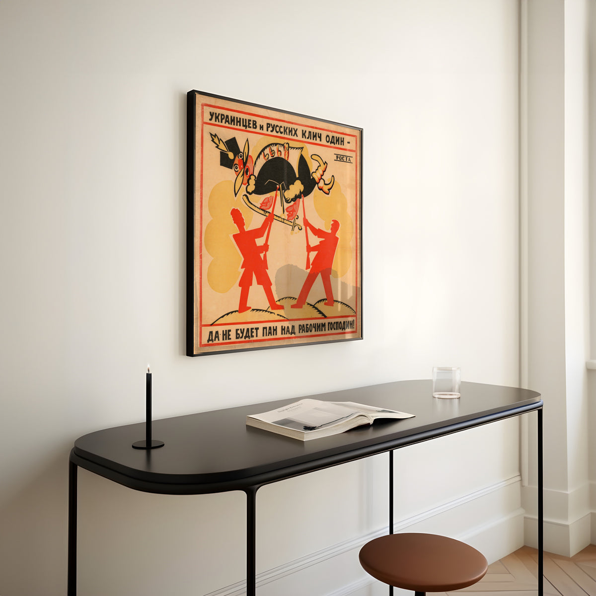 Framed art print of The Cry of Ukrainians and Russians Is One: Let No Lord Be Master Over the Worker! by Vladimir Mayakovsky, above a slim black console table