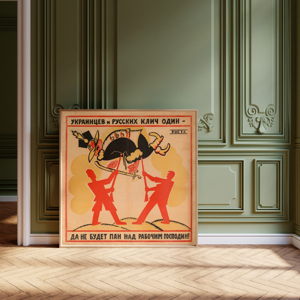 Framed art print of The Cry of Ukrainians and Russians Is One: Let No… by Vladimir Mayakovsky, leaning against olive-green panelling on a herringbone floor