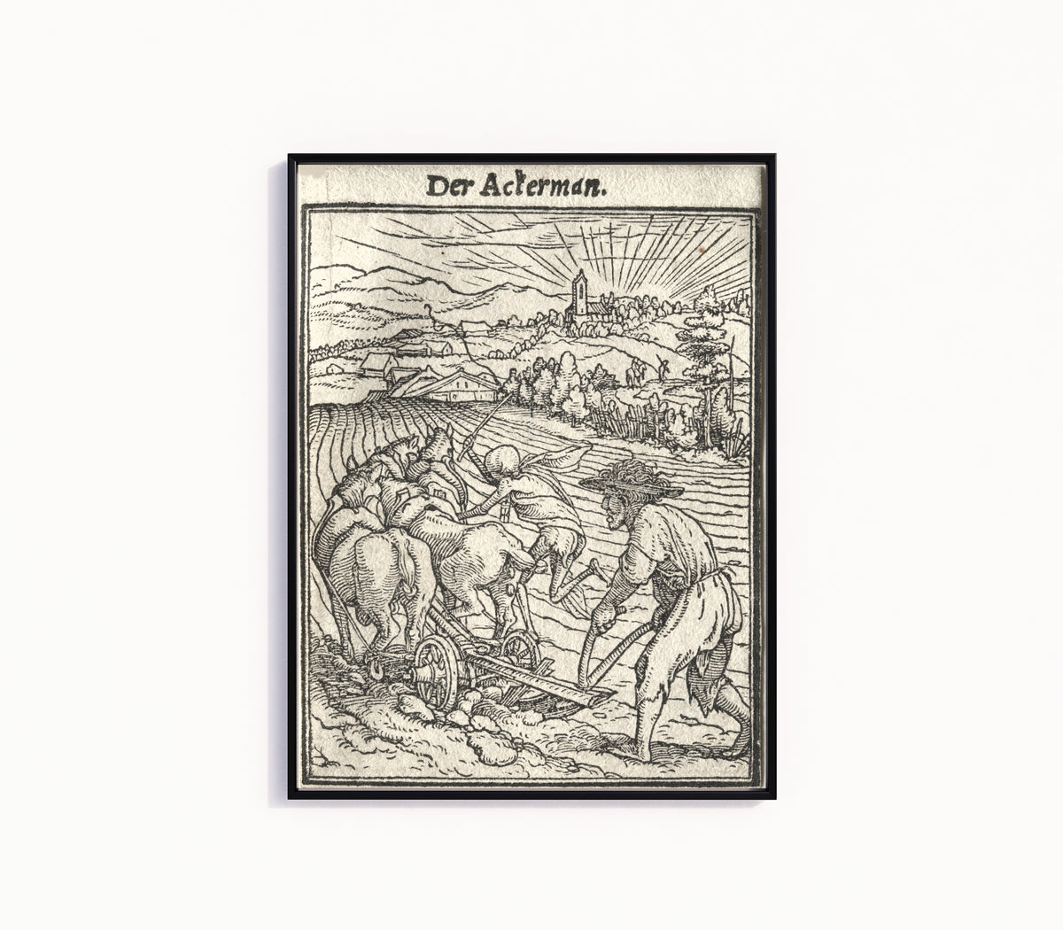 Framed art print of The Dance of Death: Der Ackerman (The Ploughman) by Hans Holbein the Younger, in a slim black frame on a plain white wall