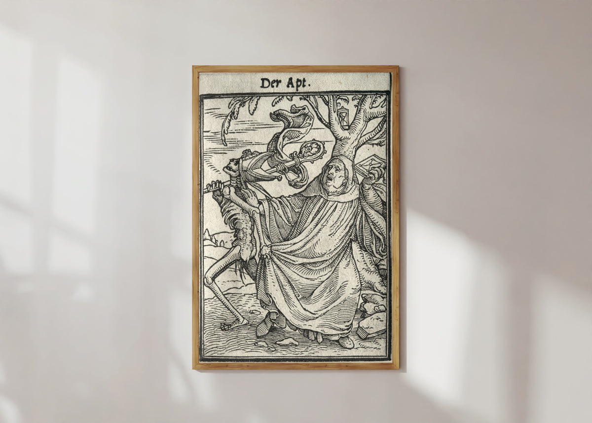 Framed art print of The Dance of Death: Der Apt (The Abbot) by Hans Holbein the Younger, in a light wood frame on a sunlit white wall