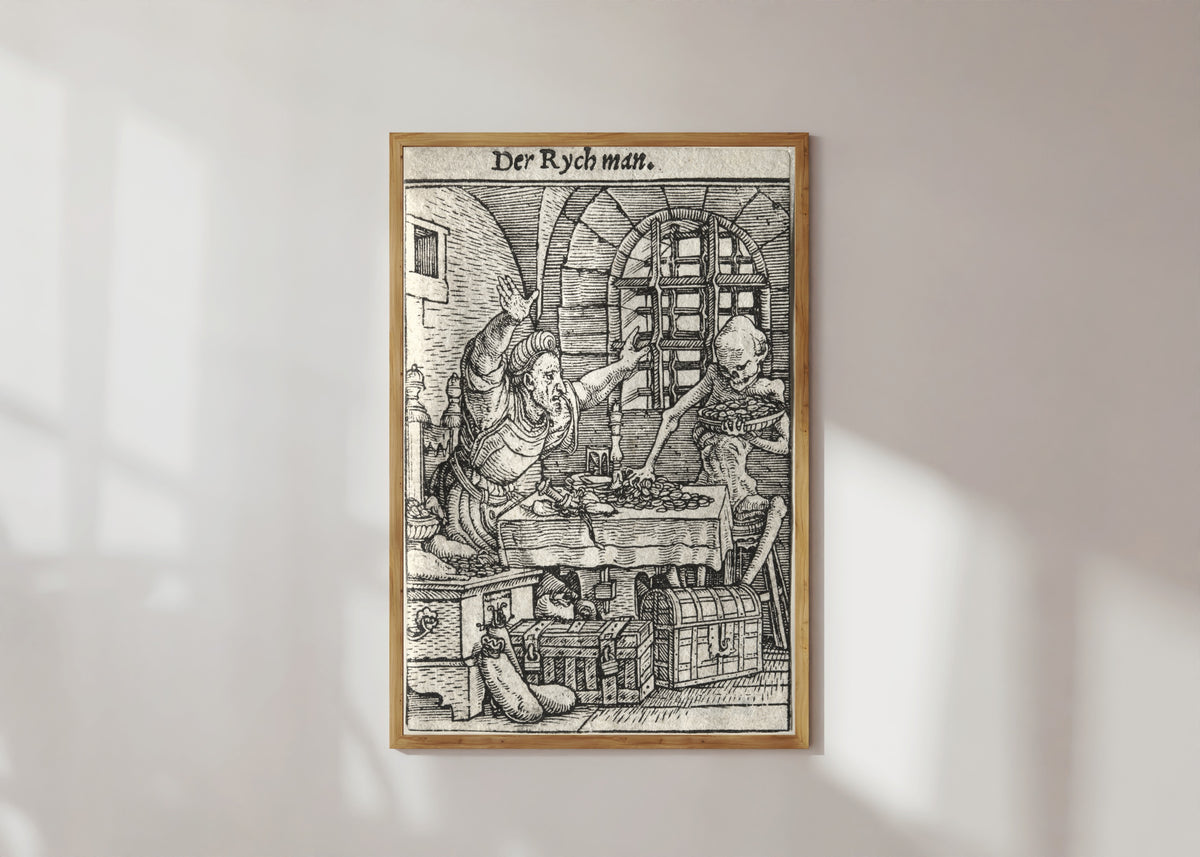 Framed art print of The Dance of Death: Der Rych man (The Miser) by Hans Holbein the Younger, in a light wood frame on a sunlit white wall