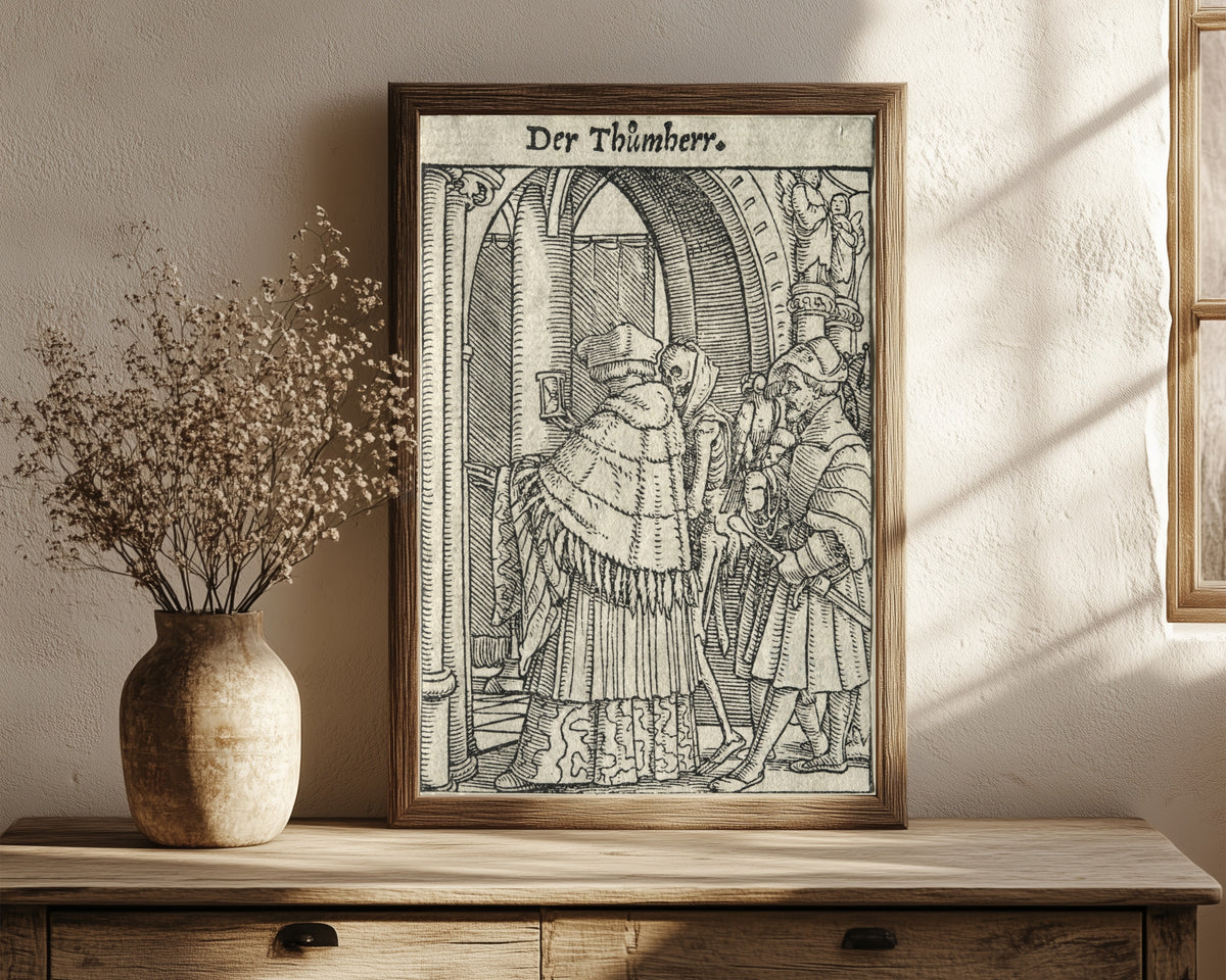 Framed art print of The Dance of Death: Der Thůmherr (The… by Hans Holbein the Younger, in a dark wood frame leaning on a rustic console beside dried flowers