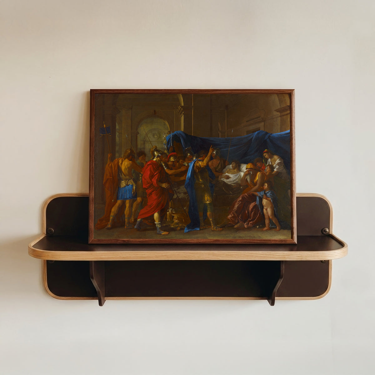 Framed art print of The Death of Germanicus by Nicolas Poussin, in a dark wood frame resting on a wall shelf