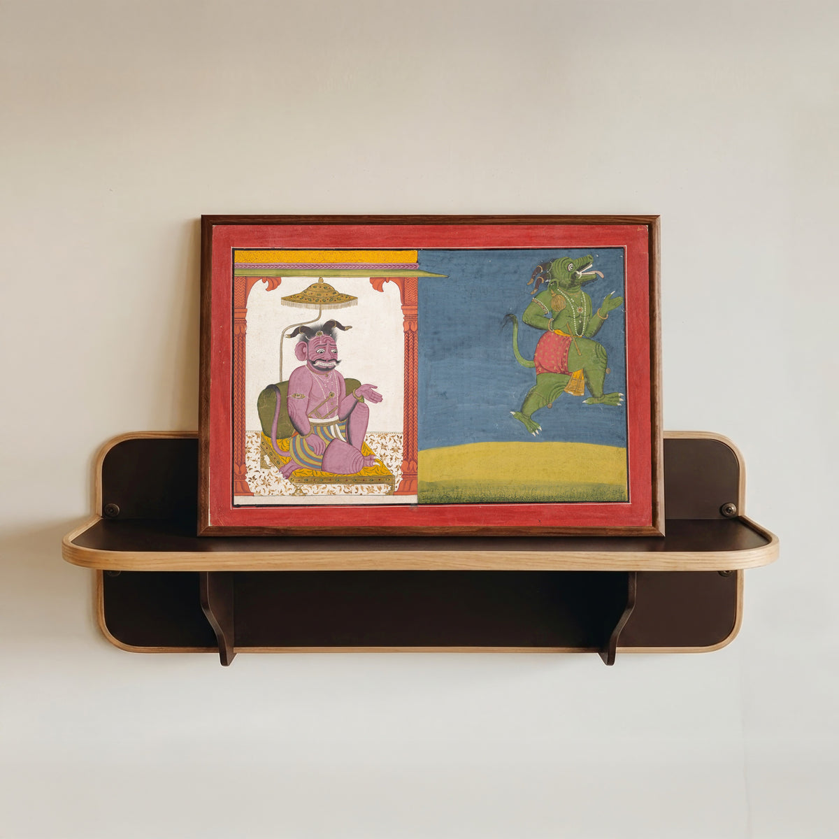 Framed art print of The Demon Hiranyaksha Departs the Demon Palace by Guler school, in a dark wood frame resting on a wall shelf
