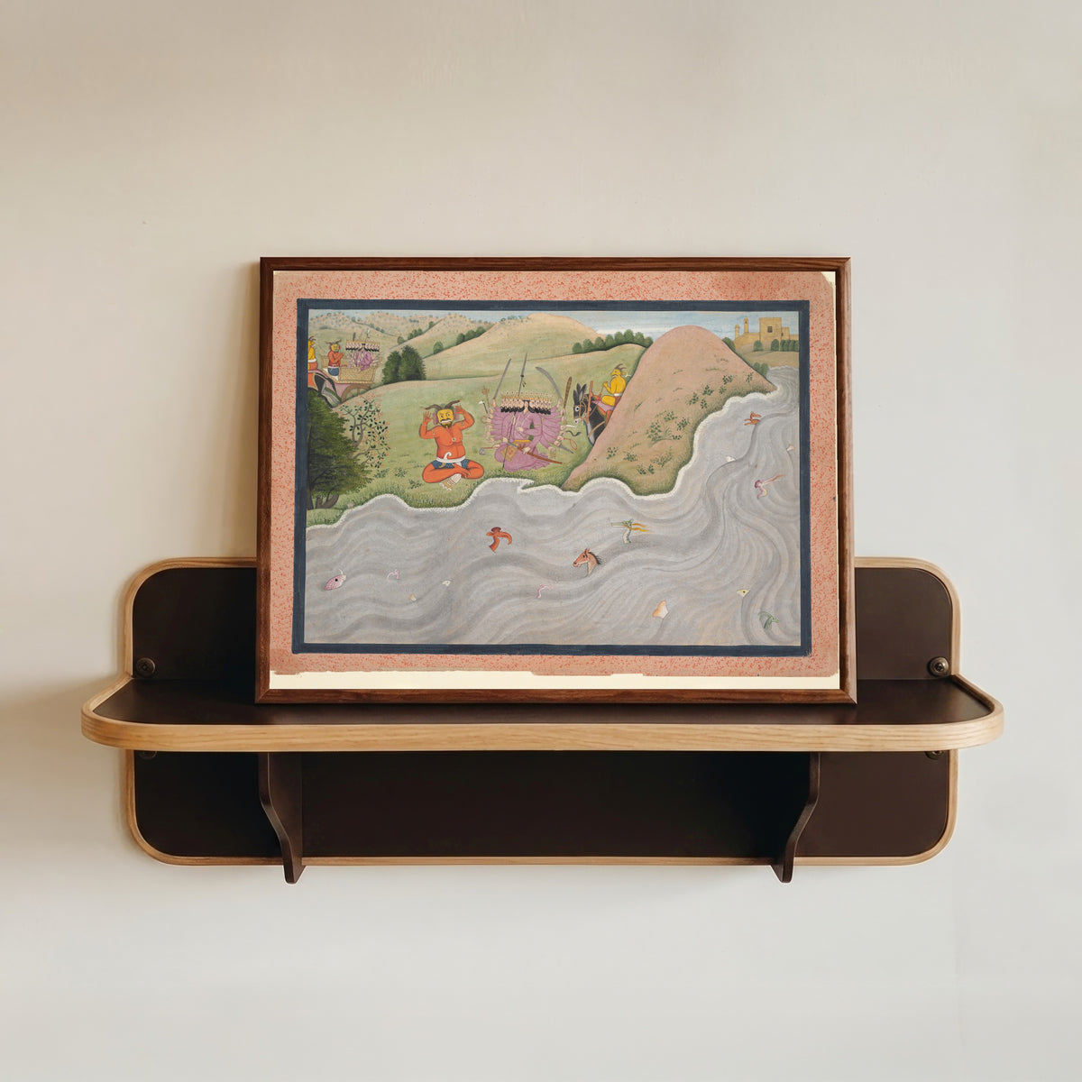 Framed art print of The Demon Marichi Tries to Dissuade Ravana by Kangra school, in a dark wood frame resting on a wall shelf