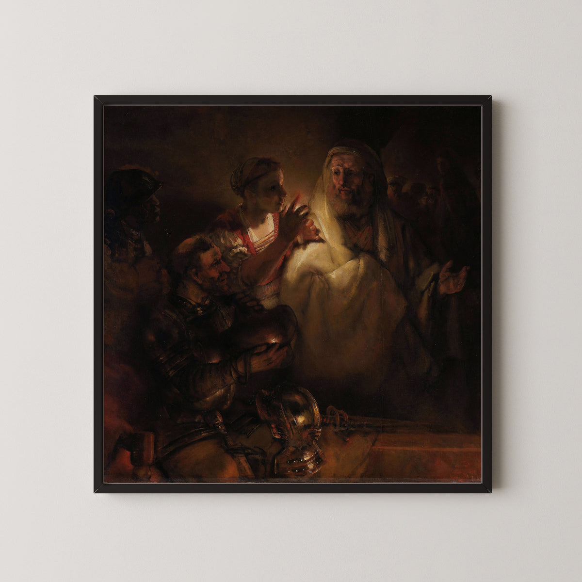 Framed art print of The Denial of St Peter by Rembrandt van Rijn, in a black frame on a pale wall