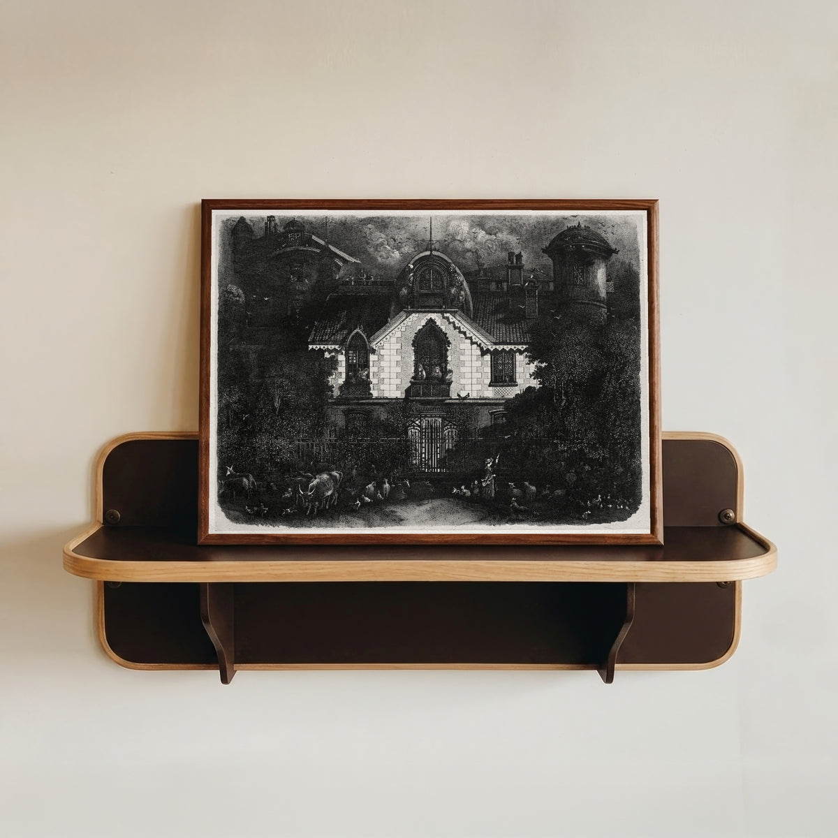 Framed art print of The Enchanted House by Rodolphe Bresdin, in a dark wood frame resting on a wall shelf