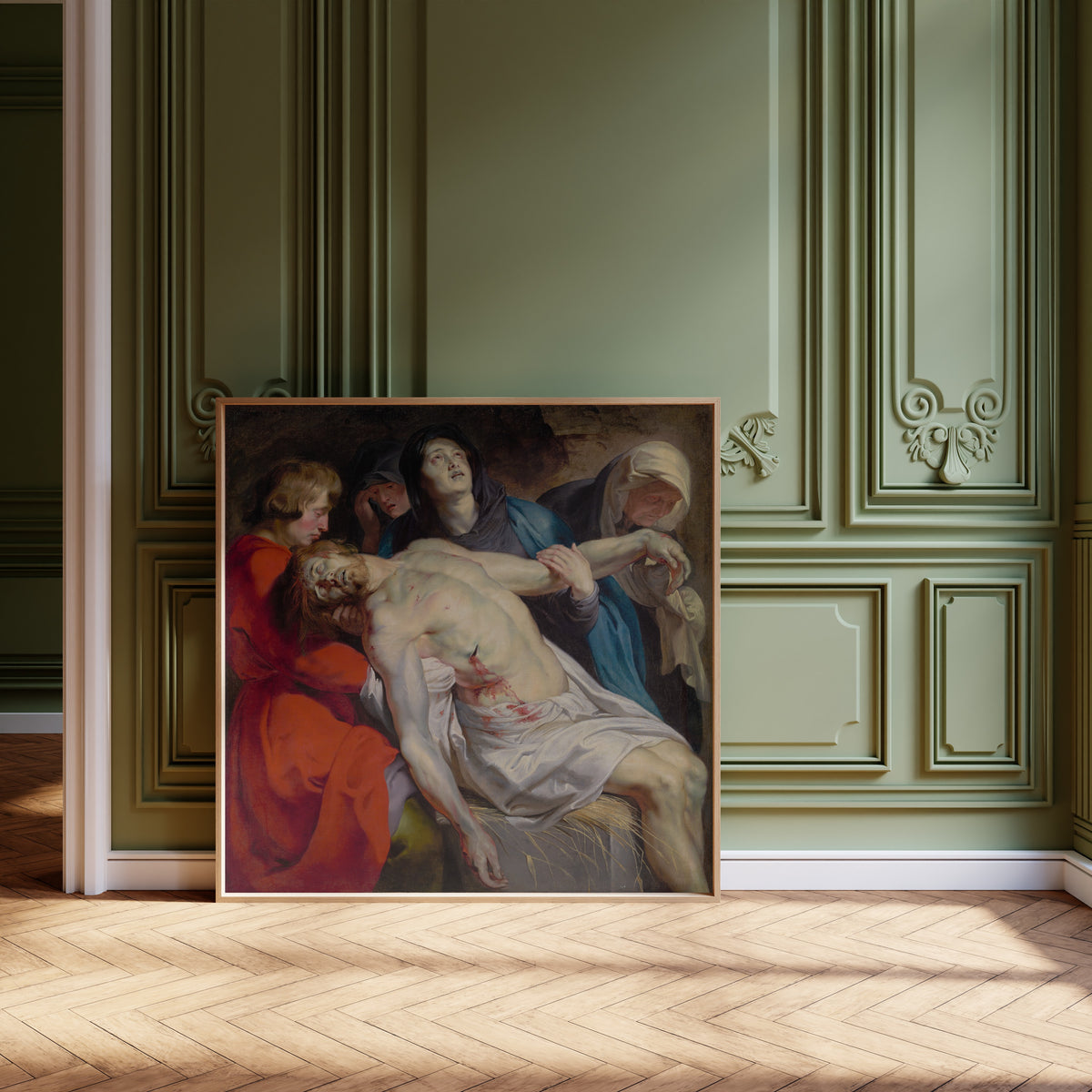 Framed art print of The Entombment by Peter Paul Rubens, leaning against olive-green panelling on a herringbone floor