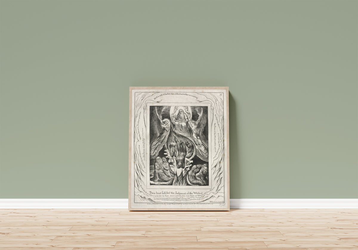 Framed art print of The Fall of Satan (Book of Job, Plate 16) by William Blake, in a light wood frame leaning on a sage green wall above a wooden floor