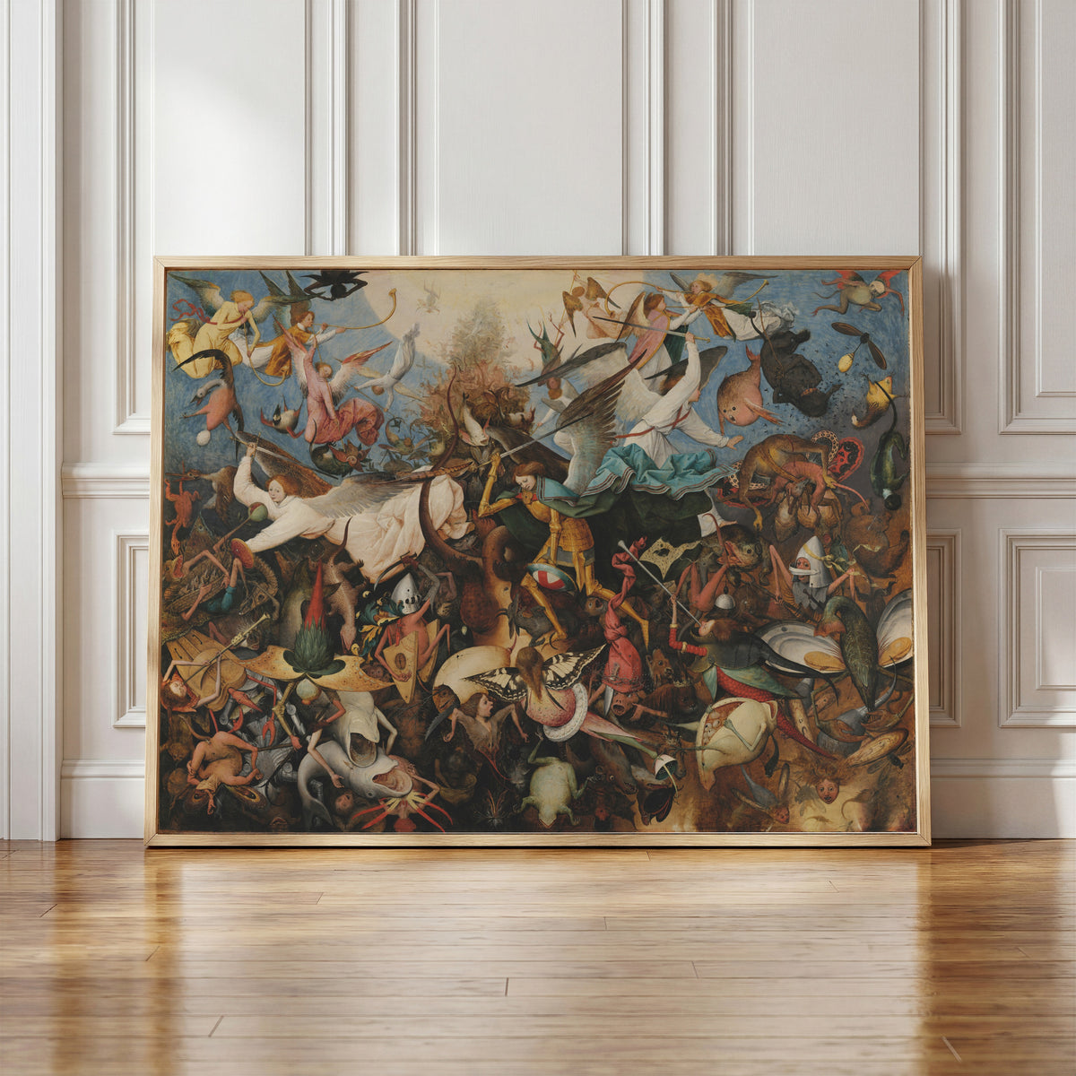 Framed art print of The Fall of the Rebel Angels by Pieter Bruegel the Elder, in a light wood frame leaning against a panelled white wall