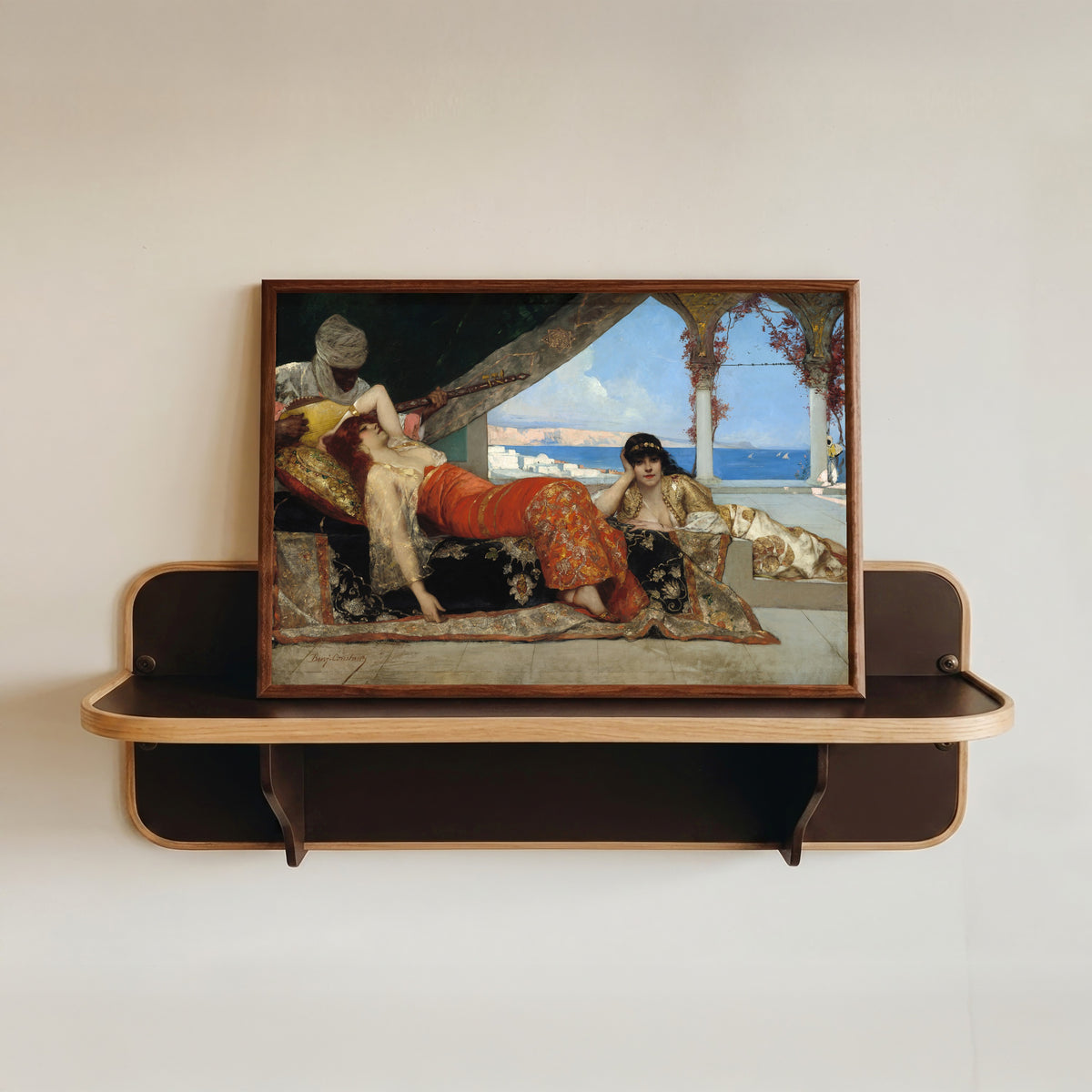 Framed art print of The Favorite of the Emir by Jean-Joseph Benjamin-Constant, in a dark wood frame resting on a wall shelf
